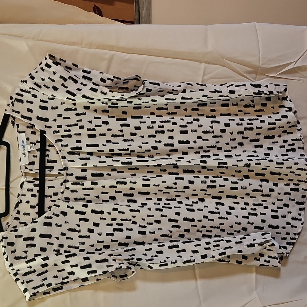 Alice Blue Top In A Size Large. White Background With A Black Abstract Design